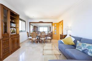 sala de estar con sofá azul y comedor en Chalet con vistas al mar en Santa Cruz de Tenerife en Santa Cruz de Tenerife