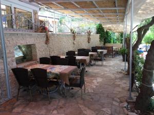 a patio with tables and chairs and a fireplace at Rooms by the sea Hvar - 8785 in Hvar