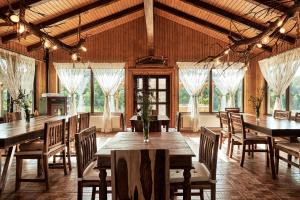 a dining room with tables and chairs and windows at Casa Chilia Resort&Spa in Chilia Veche