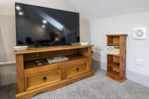ブリクサムにあるHarbour View- Cosy Maisonette, Close to Brixham Harbourの木製ドレッサーに座った薄型テレビ