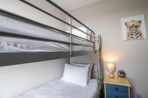 ブリクサムにあるHarbour View- Cosy Maisonette, Close to Brixham Harbourのベッドルーム1室(二段ベッド2台、ランプ付きテーブル付)