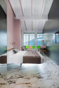 - une chambre avec un grand lit et une grande fenêtre dans l'établissement Vulcano Palace, à Castro