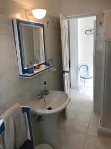La salle de bains est pourvue d'un lavabo blanc et d'un miroir. dans l'établissement Sea view houses, Praia de Chaves, Boa Vista, Cape Verde, FREE WI-FI, à Cabeçadas