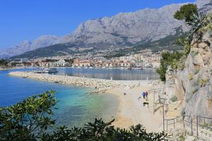 a beach with people on it next to the water at Apartments and rooms with WiFi Makarska - 11063 in Makarska