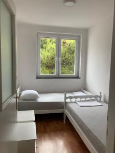 a bedroom with two beds and a window at Apartman Jelena in Mostar