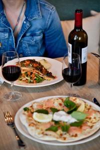 聖納澤爾的住宿－ibis Styles Saint Nazaire Centre Gare，一张桌子,上面放着两盘食物和一瓶葡萄酒
