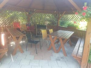 una mesa de madera y sillas bajo un cenador en Domek u Ani en Orelec