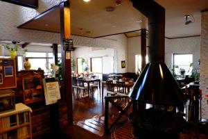 a restaurant with a fireplace in the middle of a room at Guesthouse Sakuya in Fujikawaguchiko