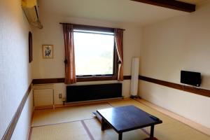 sala de estar con mesa y ventana en Guesthouse Sakuya en Fujikawaguchiko