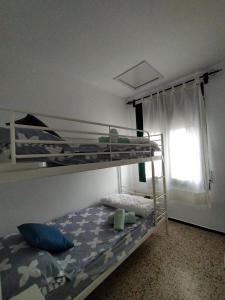 1 dormitorio con 2 literas y ventana en La Caseta, en Tamariu