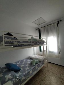 a bedroom with two bunk beds and a window at La Caseta in Tamariu +7 photos