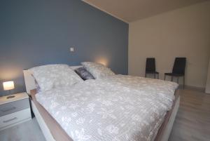 a bedroom with a large bed with two chairs at Ferienwohnung Up Hobarg 35523 in Uplengen