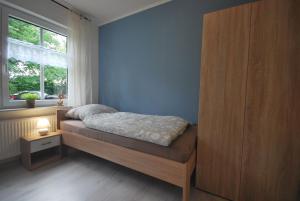a small bedroom with a bed and a window at Ferienwohnung Up Hobarg 35523 in Uplengen