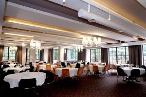 a dining room with white tables and chairs and chandeliers at Best Western Plus Paradise Hotel Dilijan in Dilijan