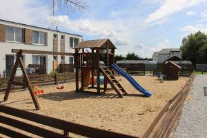 a playground with a slide in the sand at Nadmorskie Klimaty in Sarbinowo
