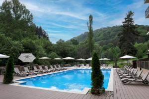 a pool with lounge chairs and umbrellas at a resort at Best Western Plus Paradise Hotel Dilijan in Dilijan