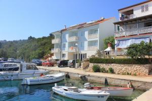 um grupo de barcos na água ao lado de um edifício em Apartments and rooms by the sea Zaglav, Dugi otok - 8144 em Sali