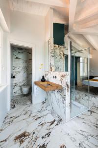 La salle de bains en marbre est pourvue d'un comptoir et d'un lavabo. dans l'établissement Vulcano Palace, à Castro