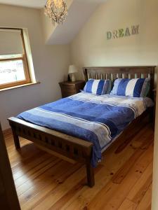 Un dormitorio con una cama con sábanas azules y una lámpara de araña. en Beautiful Central 3-Bed House in Co Clare en Miltown Malbay