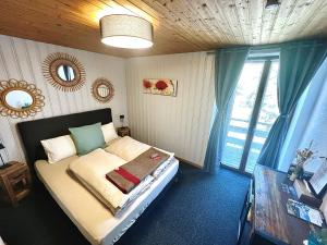 um quarto com uma cama com um espelho e uma janela em Hôtel Restaurant Les Cernets Swiss-Lodge SSH em Les Verrières