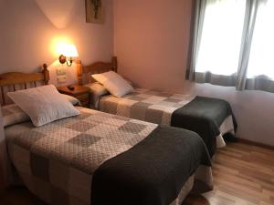 a hotel room with two beds and a window at Hotel Saueth in Tredós