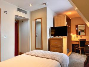 a hotel room with a bed and a desk and a television at Beresford Hotel in Dublin