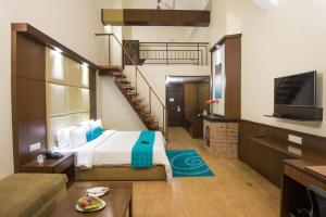 a hotel room with a bed and a staircase at Sinclairs Retreat Kalimpong in Kalimpong