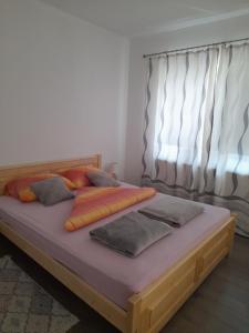 a bedroom with a large bed and a window at Studio Apartments Adian in Korenica