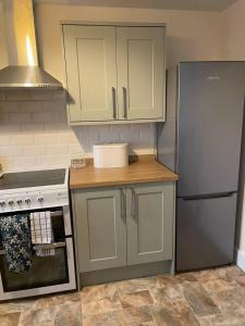 a kitchen with a refrigerator and a stove at Glen Cottage 8 Fenton Hill Farm in Wooler