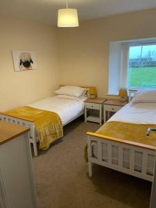 a hotel room with two beds and a window at Glen Cottage 8 Fenton Hill Farm in Wooler