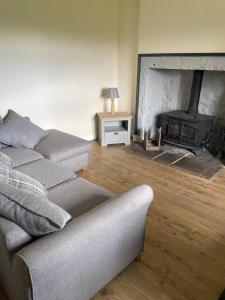 a living room with a couch and a fireplace at Tweed Cottage 4 Fenton Hill in Wooler