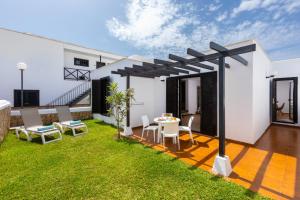 a patio with a table and chairs in a yard at Los Cardones Boutique Village in Playa de las Americas