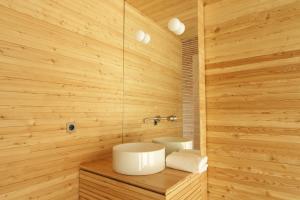 uma casa de banho com um lavatório branco e paredes de madeira em LILELO - Little Leisure Lodge em Grazzano Badoglio