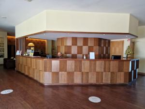 Um homem sentado num balc�o na entrada. em Hotel Da Montanha em Pedr�g�o Pequeno mais 37 fotografias