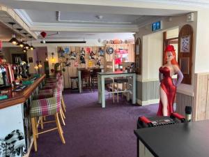 ein Restaurant mit einer Frauenstatue in der Mitte eines Raumes in der Unterkunft Hatters Hotel in Skegness