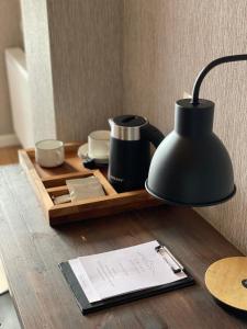 a desk with a black lamp and a tray with cups at Capra Hotel Kazbegi in Stepantsminda