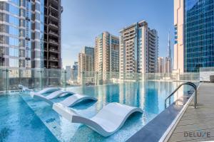 a swimming pool in a city with tall buildings at Classy 1BR at Bayz by Danube Business Bay by Deluxe Holiday Homes in Dubai