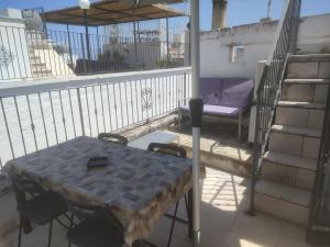 balkon ze stołem, łóżkiem i schodami w obiekcie Le Terrazze Ferrigni w mieście Ostuni
