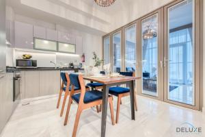 a kitchen with a wooden table and blue chairs at Classy 1BR at Bayz by Danube Business Bay by Deluxe Holiday Homes in Dubai