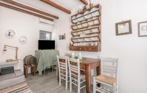 a dining room with a table and a tv at Olive Cottage in Zefiría