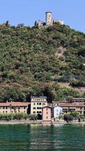 a building on a hill next to a body of water at Sensole locanda contemporanea in Monte Isola