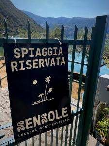 ein Schild an einem Tor mit einem Schild darauf in der Unterkunft Sensole locanda contemporanea in Monte Isola