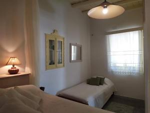 a bedroom with two beds and a mirror and a window at Grandpa's Traditional Guesthouse in Amorgos +26 photos