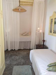 a bedroom with two beds with white curtains at Grandpa's Traditional Guesthouse in Amorgos