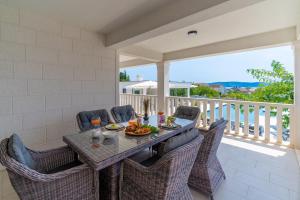 ein Esszimmer mit Tisch und Stühlen auf einem Balkon in der Unterkunft Villa Marisa with 51sqm pool, 5 bedrooms, gym in Kaštela