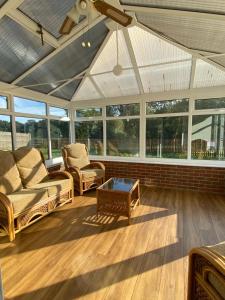 a screened in porch with chairs and a coffee table at Beautiful newly renovated 5 bedroom farmhouse in Belton