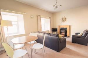 een woonkamer met een bank en een tafel en stoelen bij Cathedral View Apartments in Longford