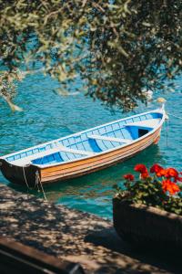 un barco sentado en el agua junto a unas flores en Sensole locanda contemporanea, en Monte Isola