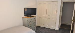 um quarto com uma cama e uma televisão numa cómoda em Fore Street Bodmin em Bodmin