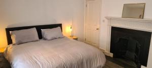 um quarto com uma cama grande e uma lareira em Fore Street Bodmin em Bodmin